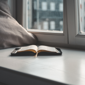 Raamattu ikkunalla tyynyn vieressä