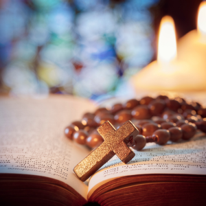 Raamattu, rukousnauha ja kynttilä