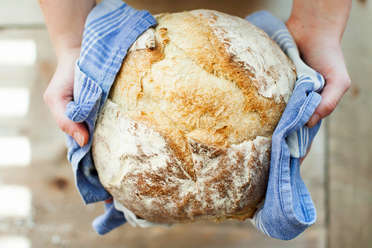 Kädet ojentavat leipää.